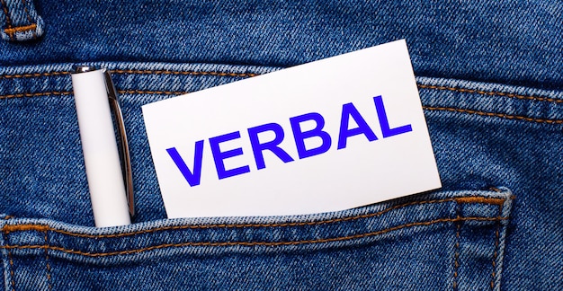 El bolsillo trasero de los jeans azules contiene un bolígrafo blanco y una tarjeta blanca con el texto VERBAL