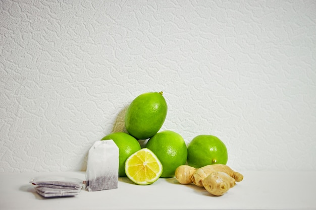 Bolsitas de té y jengibre de limón sobre un fondo blanco.