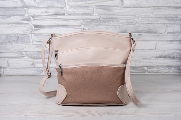 Un bolso beige con una correa que dice 'bolso'