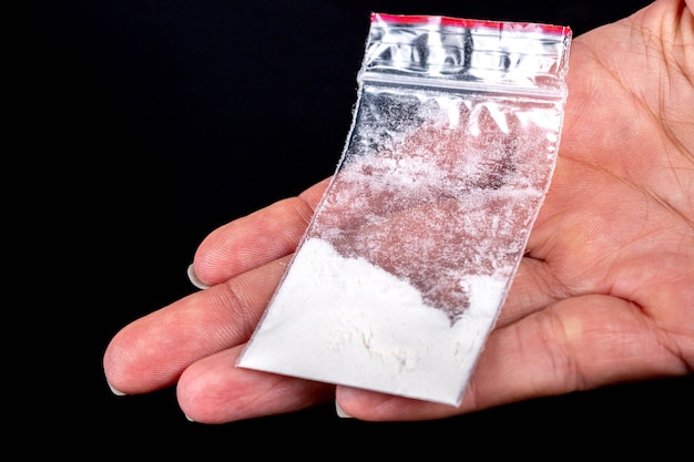 Foto bolso com pó branco na mão. drogas ilegais.