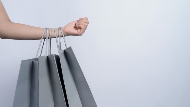 Bolso de compras de color gris sostenido por el brazo de la mujer asiática de negocios y el fondo blanco.