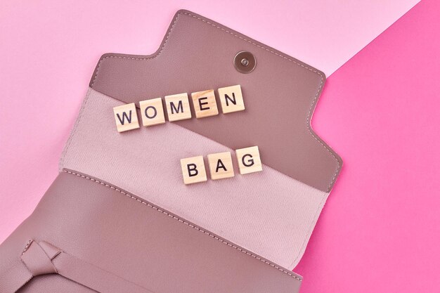 Bolso de cuero rosa y bolso de mujer con inscripción en cubos de madera.