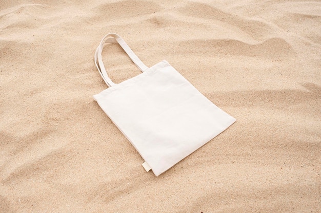 Bolso de lona na praia de areia mock up design