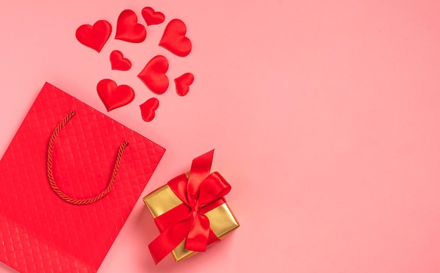 Bolso de papel vermelho corações vermelhos presente fita de cetim laço fundo rosa fundo festivo dia de São Valentim