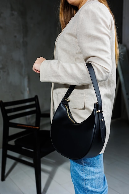 Bolso elegante de cuero para mujer Un bolso clásico negro para todos los días en manos de una mujer