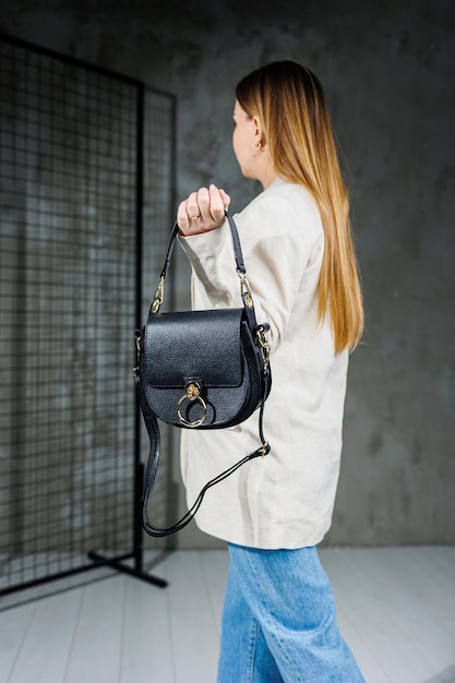 Bolso elegante de cuero para mujer Un bolso clásico negro para todos los días en manos de una mujer