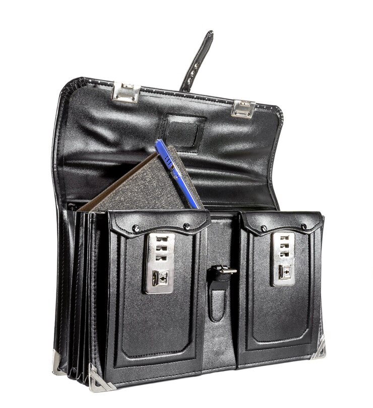 Bolso escolar de cuero negro retro con cuaderno en el fondo