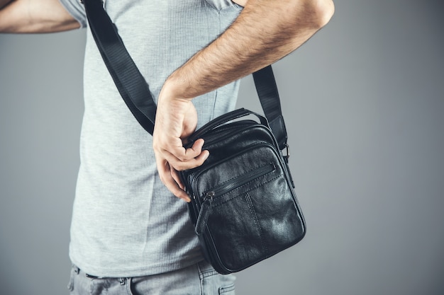 Bolso de mano de hombre negro sobre gris