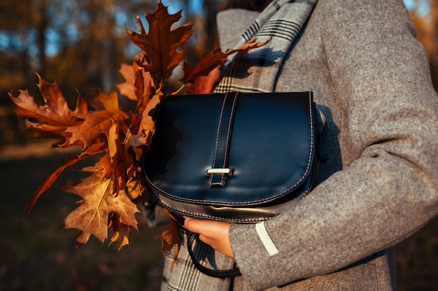 Bolso. Mujer joven con bolso elegante y abrigo