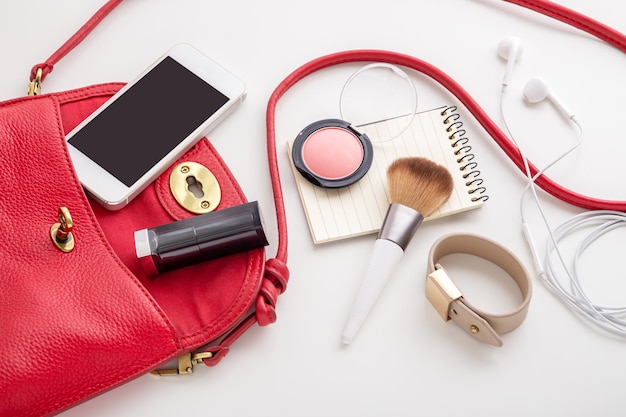 Bolso de mujer de piel roja con cosmética, teléfono y complementos