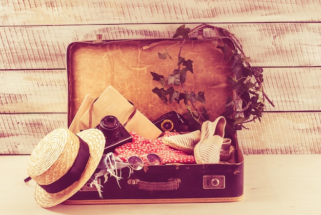 Foto bolso retro para vocación de verano con libro de cámara fotográfica y sombrero de mimbre