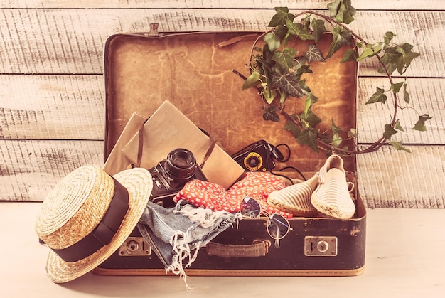 bolso retro para vocación de verano con libro de cámara fotográfica y sombrero de mimbre