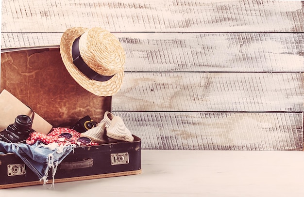 Foto bolso retro para vocación de verano con libro de cámara fotográfica y sombrero de mimbre