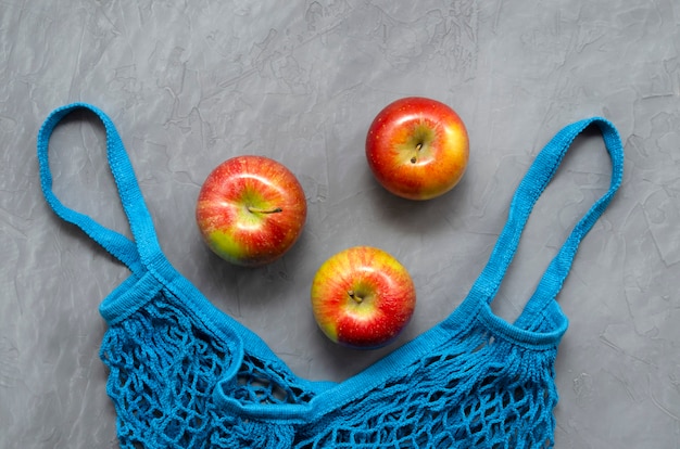Bolso shopping eco zero waste de malla azul con frutas manzanas rojas