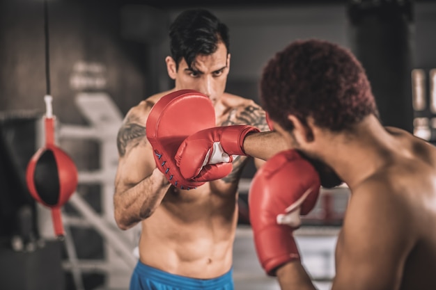 Bom chute. Dois kickboxers trabalhando em chutes em uma academia