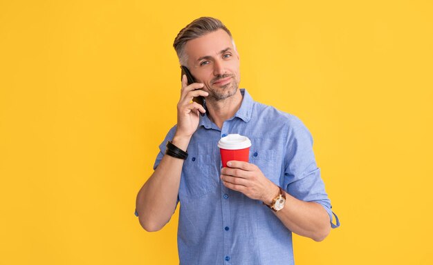 Bom dia comunicação homem bonito usa smartphone com xícara de café