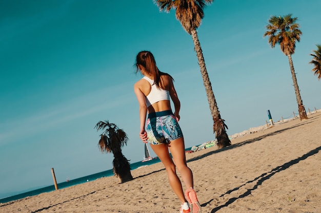 Bom dia para treinar. Retrovisor de uma bela jovem em roupas esportivas correndo enquanto se exercita ao ar livre