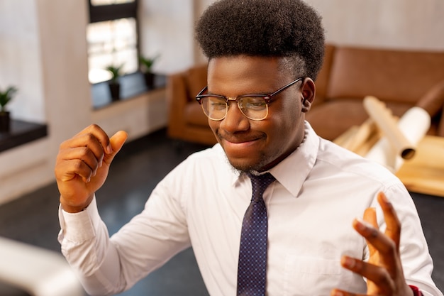 Bom homem inteligente mostrando suas emoções ao fazer uma tarefa difícil no trabalho