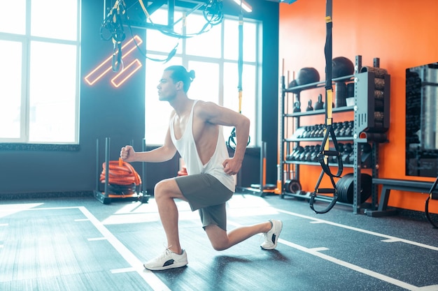 Bom jovem fazendo um exercício esportivo