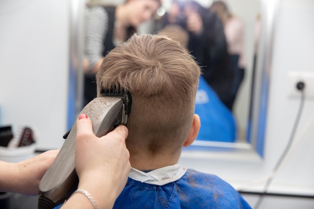 Bom menino europeu recebendo penteado na barbearia