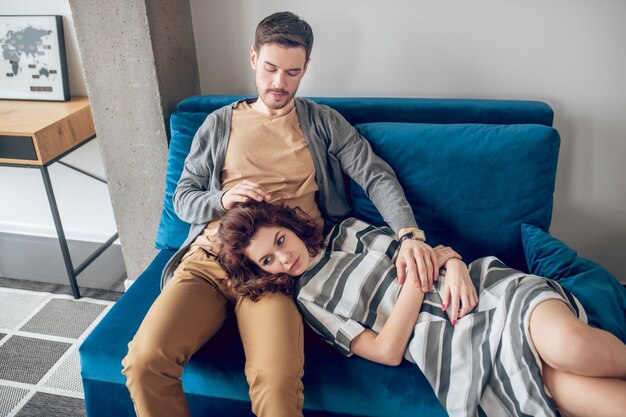 Foto bom momento. jovem casal sentado no sofá, descansando e se sentindo confortável