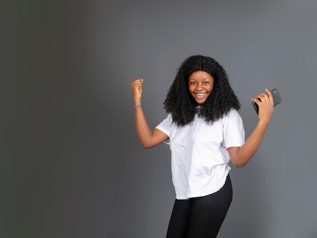 bom positivo feliz atraente adolescente africana segurando o telefone celular