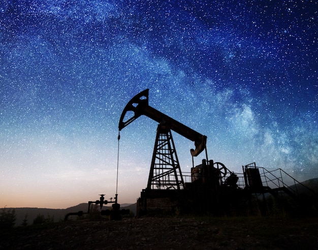 Bomba de aceite en el campo petrolero en la noche.