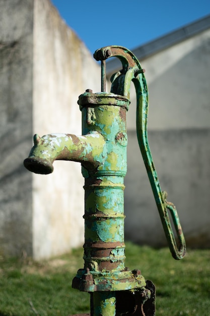 Bomba de agua manual antigua en un pozo en el jardín riego y ahorro de agua entorno rural