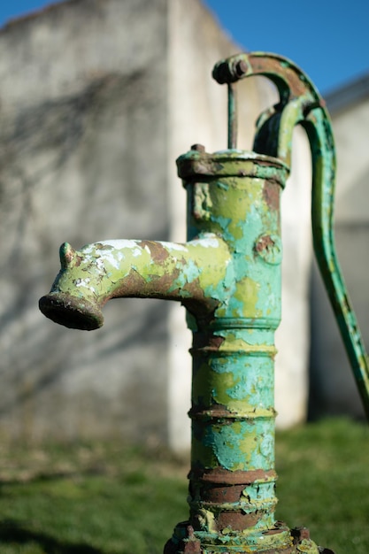 Bomba de agua manual antigua en un pozo en el jardín riego y ahorro de agua entorno rural