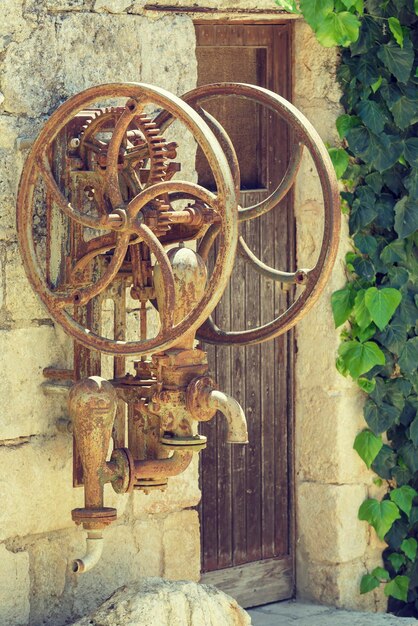 Bomba de agua manual vieja en un fondo de la puerta