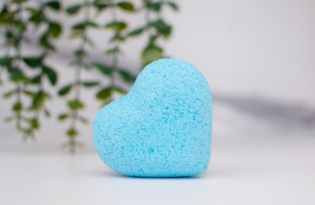 Bomba de baño en forma de corazón azul sobre fondo de mármol bombas de colores hechas a mano primer plano de la bola azul El concepto de terapia Salón de spa en casa