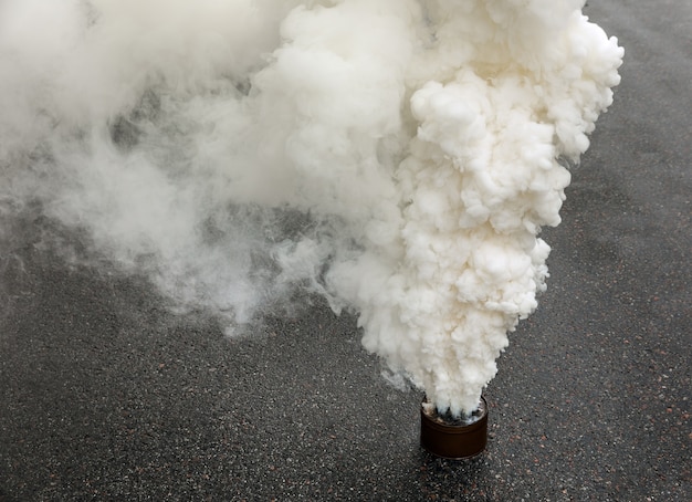 Bomba de humo humeante en la carretera durante la acción de protesta