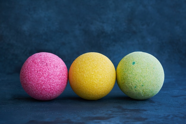 Bombas de baño de colores sobre fondo azul. Copiar espacio para texto