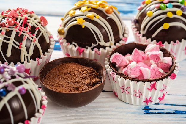 Foto bombas de cacau são cascas de chocolate preto cheias de cacau em pó e marshmallows