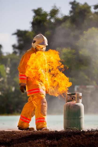 Bombeiro com fogo e terno para proteger bombeiro para treinar bombeiros