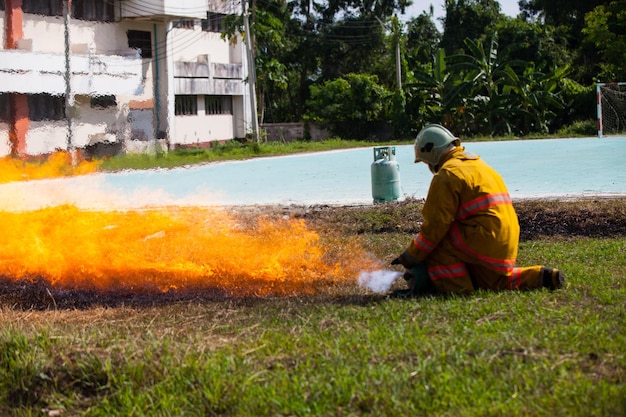 Bombeiro com fogo e terno para proteger bombeiro para treinar bombeiros