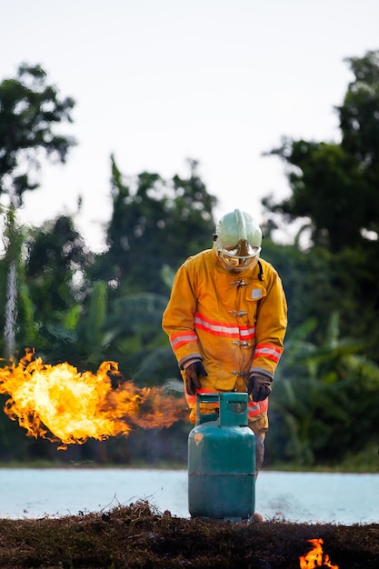 Bombeiro com fogo e terno para proteger bombeiro para treinar bombeiros