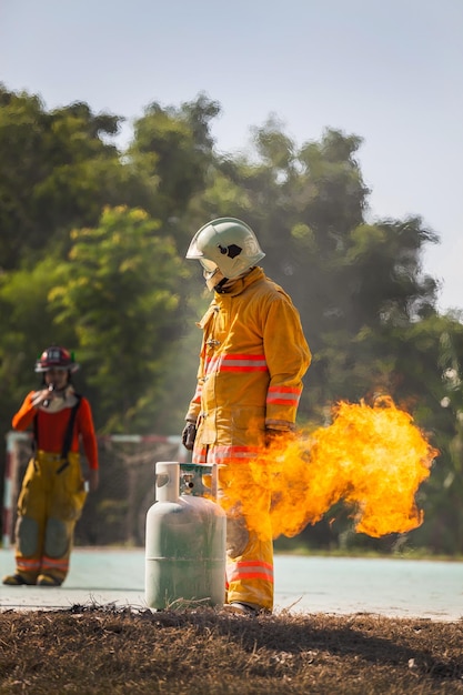 Bombeiro com fogo e terno para proteger bombeiro para treinar bombeiros