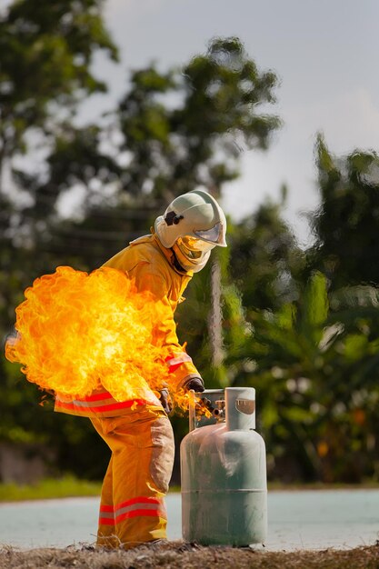 Bombeiro com fogo e terno para proteger bombeiro para treinar bombeiros