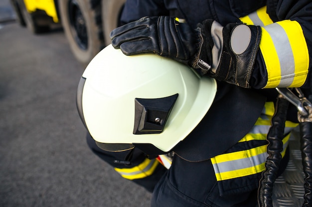 Bombeiro de resgate em capacete e uniforme seguros