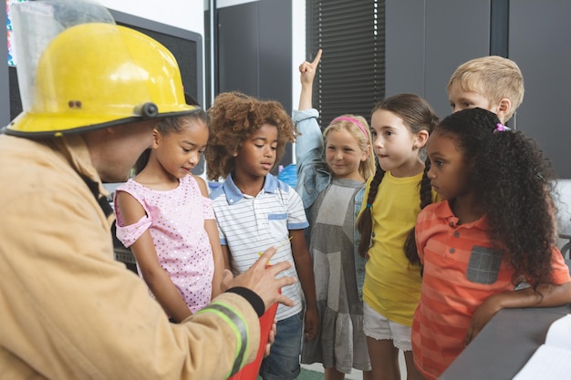 Bombeiro ensinando sobre extintor de incêndio para crianças em sala de aula
