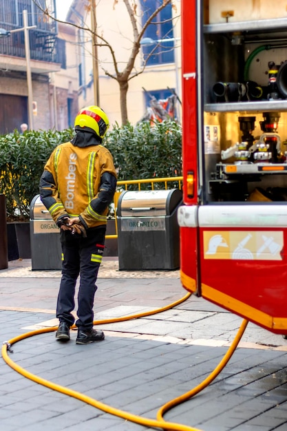 Bombeiros Bombeiro com mangueira de incêndio no chão saindo do caminhão