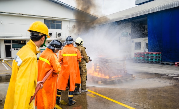 Foto bombeiros combatendo fogo durante o treinamento