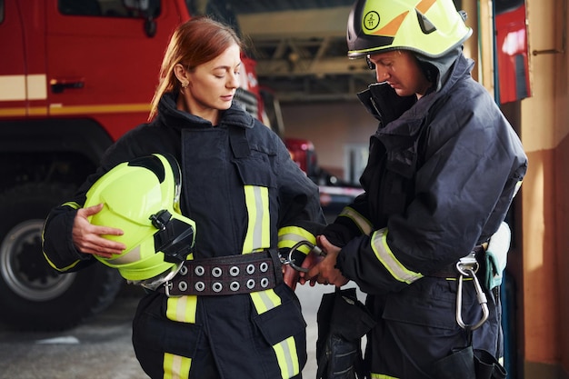 Bombeiros masculinos e femininos em uniforme de proteção juntos