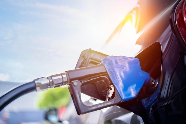 Foto bombeo de combustible de gasolina en coche negro en la gasolinera