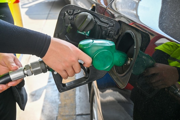 Foto bombeo de gasolina en la bomba de gasolina hombre bombeando gasolina a mano en el coche en la gasolinera