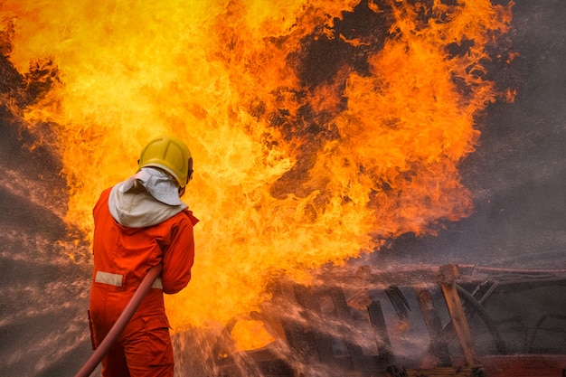 Bombero está utilizando agua en la operación de lucha contra incendios.