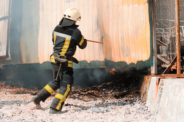 Foto bombero extingue el fuego. el concepto de salvar a las personas en un incendio