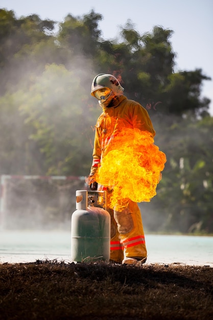 Bombero con fuego y traje para proteger al bombero para entrenar a los bomberos