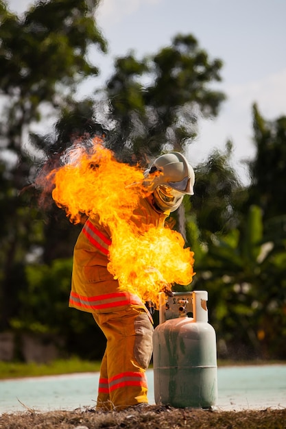 Bombero con fuego y traje para proteger al bombero para entrenar a los bomberos